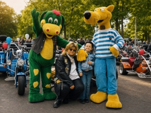 Gabi Thomayer und ein Kind zwischen den Kinderfahrt-Maskottchen Hein Blöd und Fauchi, umgeben von zahlreichen Trikes.